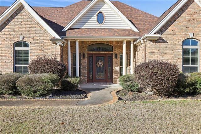 entrance to property with a yard and covered porch