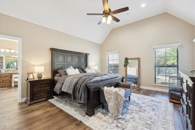 bedroom with lofted ceiling, wood-type flooring, and ceiling fan