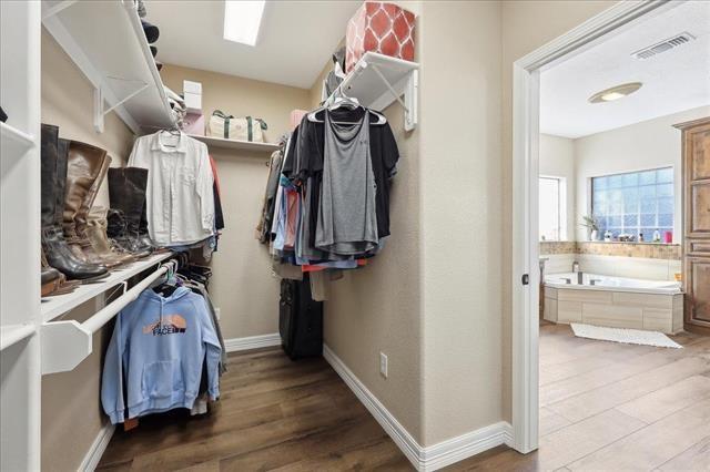 walk in closet featuring a skylight and wood-type flooring