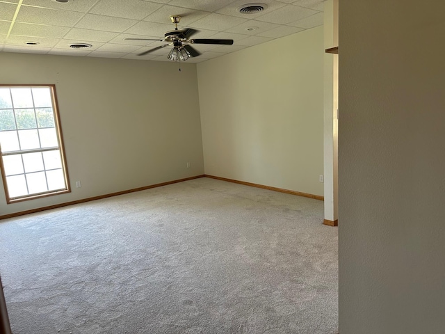 carpeted spare room featuring a paneled ceiling and ceiling fan