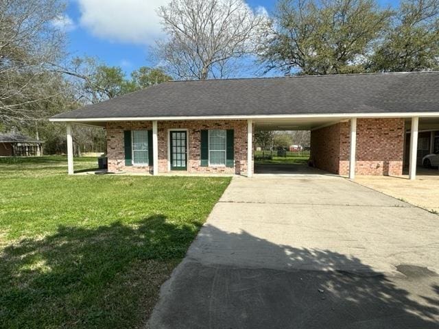 ranch-style home featuring a front lawn and a carport