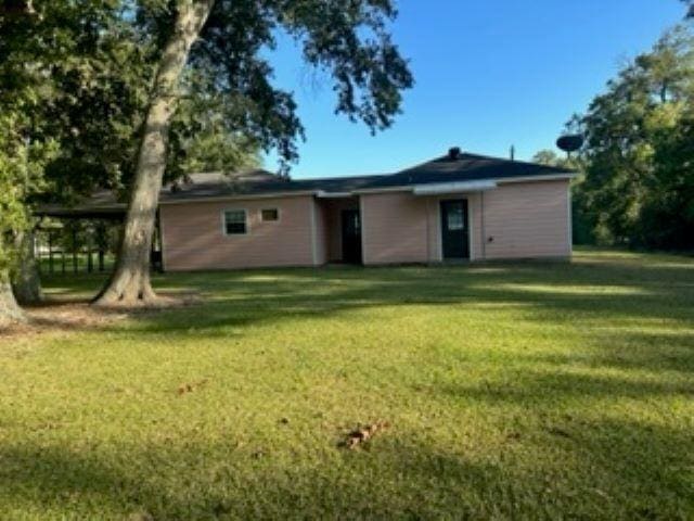 back of property featuring a lawn