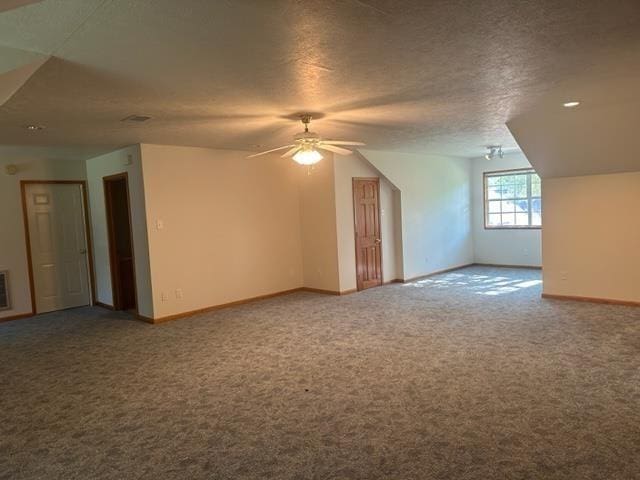 additional living space with ceiling fan, vaulted ceiling, carpet floors, and a textured ceiling