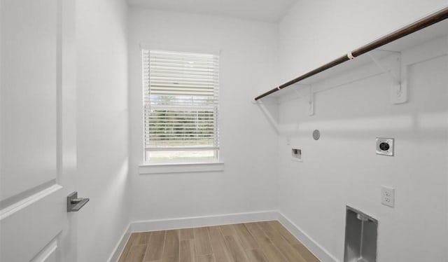 clothes washing area with washer hookup, hookup for a gas dryer, hookup for an electric dryer, and light wood-type flooring