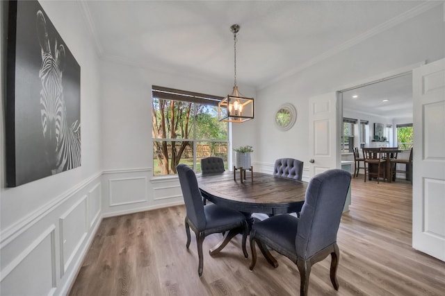 dining area featuring hardwood / wood-style flooring, ornamental molding, and a chandelier