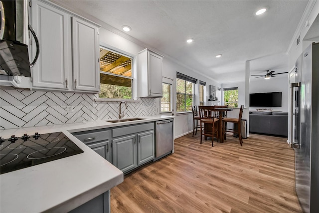 kitchen featuring sink, crown molding, gray cabinets, stainless steel appliances, and light hardwood / wood-style floors