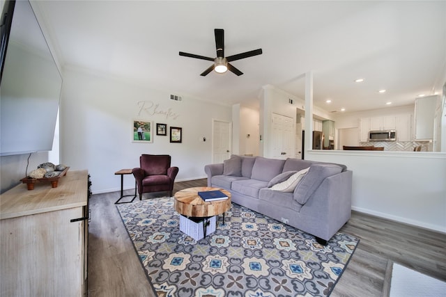 living room with wood-type flooring, ceiling fan, and crown molding