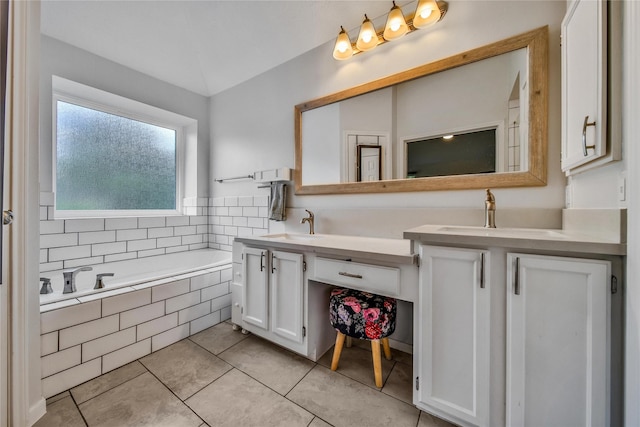 bathroom featuring tile patterned flooring, vanity, and a relaxing tiled tub