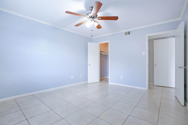 unfurnished bedroom featuring ornamental molding, light tile patterned flooring, ceiling fan, and a closet