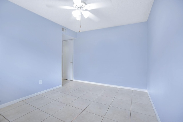 tiled empty room featuring ceiling fan