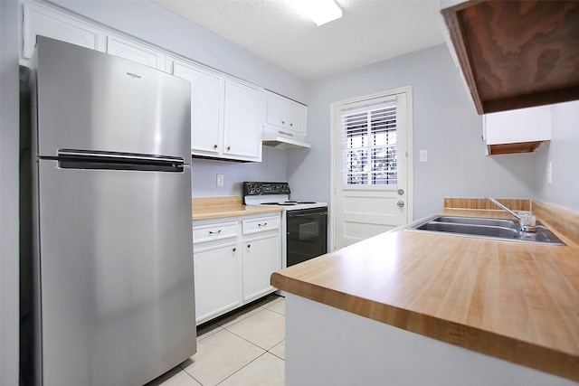 kitchen with sink, white cabinetry, electric range oven, light tile patterned floors, and stainless steel refrigerator