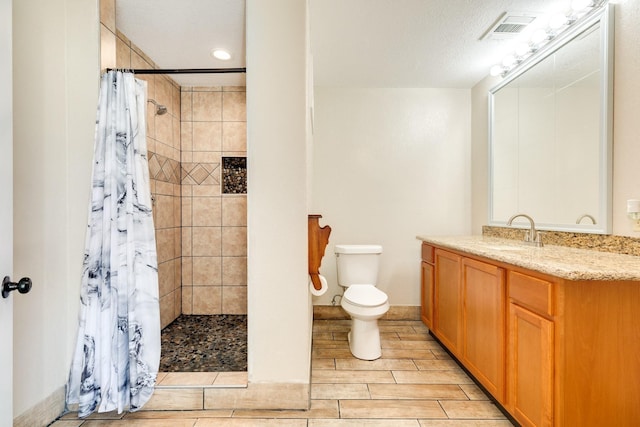 bathroom with vanity, curtained shower, and toilet