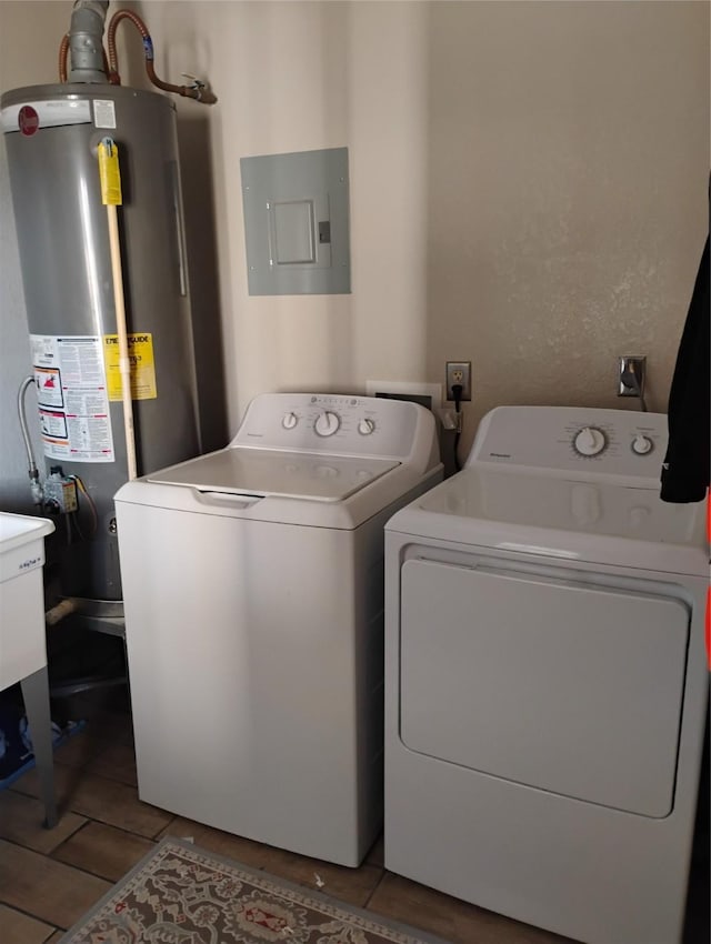 washroom featuring water heater, electric panel, and washer and clothes dryer