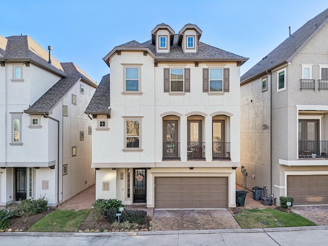 french provincial home with a balcony and a garage