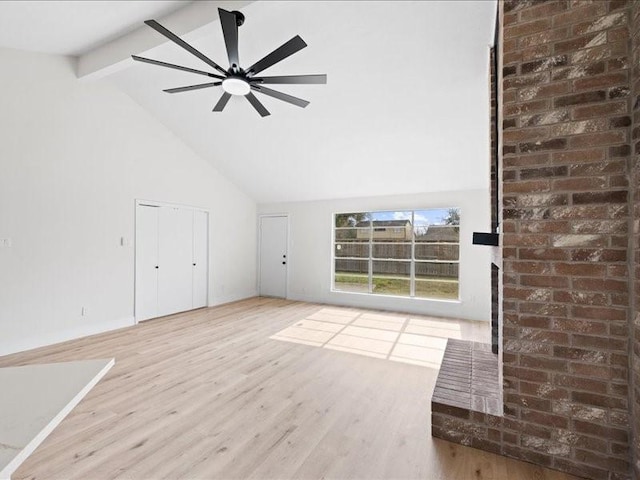 unfurnished living room with hardwood / wood-style flooring, ceiling fan, high vaulted ceiling, and beam ceiling