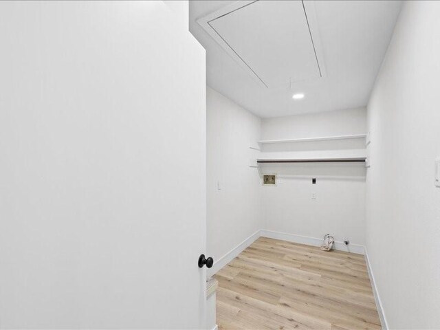 clothes washing area featuring hookup for a washing machine, hookup for a gas dryer, and light hardwood / wood-style flooring