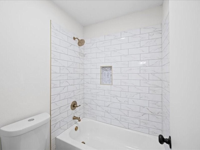 bathroom with toilet and tiled shower / bath