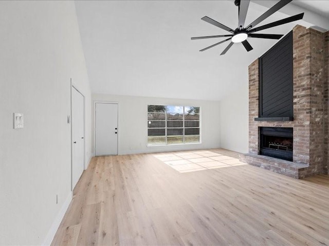 unfurnished living room with a fireplace, high vaulted ceiling, ceiling fan, and light wood-type flooring