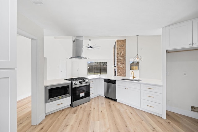 kitchen with sink, white cabinetry, appliances with stainless steel finishes, island exhaust hood, and light hardwood / wood-style floors