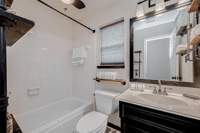 full bathroom with ceiling fan, tiled shower / bath, vanity, and toilet