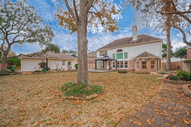 rear view of house with a gazebo and a lawn