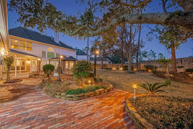 deck at dusk featuring a patio area