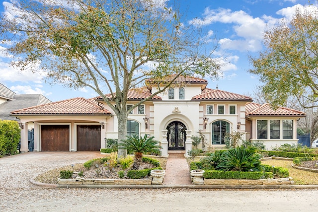 mediterranean / spanish-style house featuring a garage and french doors