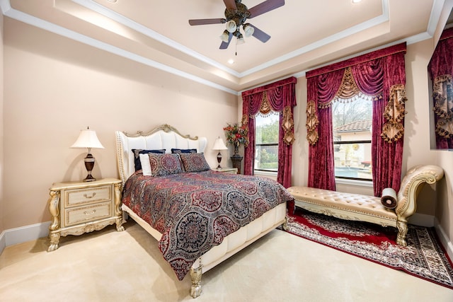 bedroom with a raised ceiling, ornamental molding, carpet, and ceiling fan