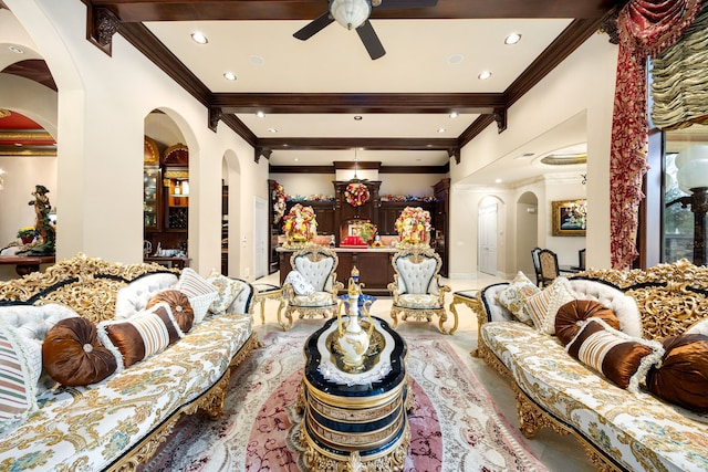 living room featuring beamed ceiling, ceiling fan, and crown molding