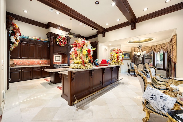 kitchen featuring a kitchen island, a kitchen bar, decorative backsplash, hanging light fixtures, and beam ceiling