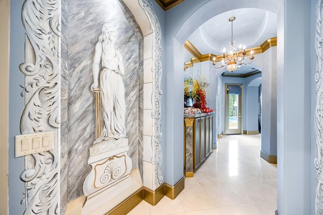 corridor featuring ornamental molding, light tile patterned floors, and an inviting chandelier