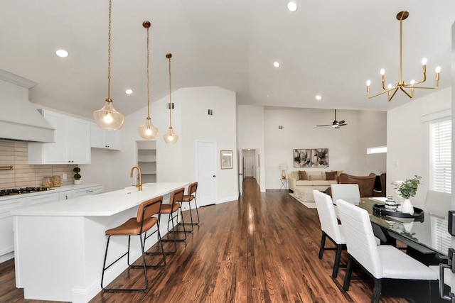 1819 Studewood St, Houston, TX 77008 - kitchen with lofted ceiling, a center island with sink, decorative backsplash, white cabinets, and light countertops
