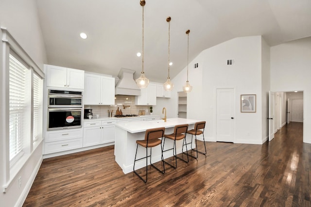 1819 Studewood St, Houston, TX 77008 - kitchen featuring custom exhaust hood, high vaulted ceiling, a kitchen island with sink, dark wood finished floors, and white cabinets