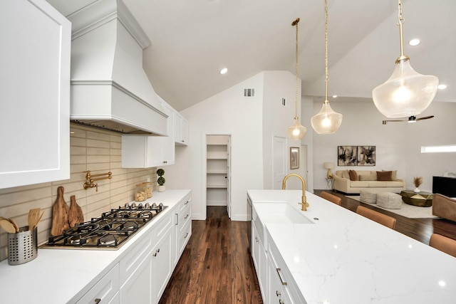 1819 Studewood St, Houston, TX 77008 - kitchen with custom exhaust hood, stainless steel gas stovetop, a sink, decorative backsplash, and light stone counters