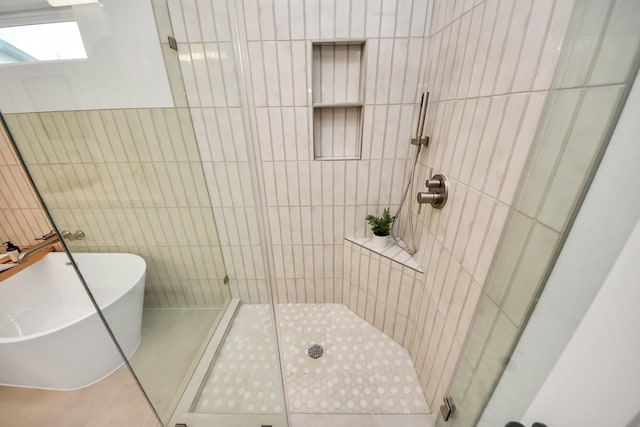 1819 Studewood St, Houston, TX 77008 - full bathroom with a shower stall, tile walls, a freestanding bath, tile patterned floors, and a skylight