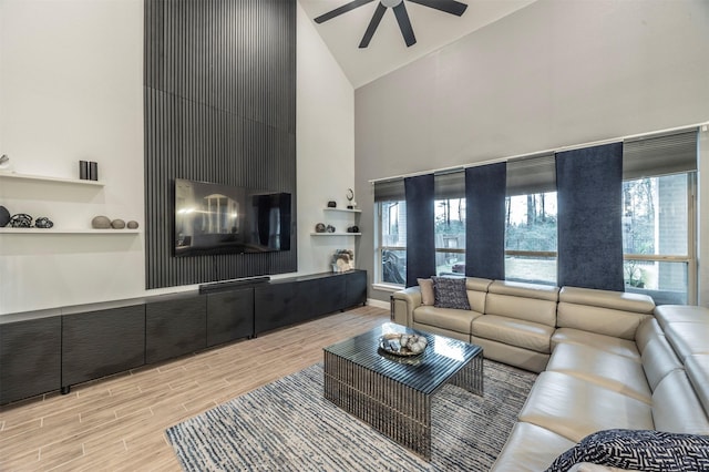 living room with ceiling fan and high vaulted ceiling