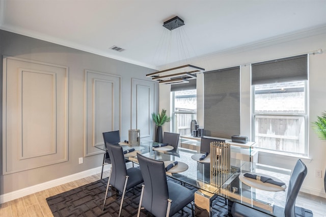 dining room with ornamental molding and light wood-type flooring