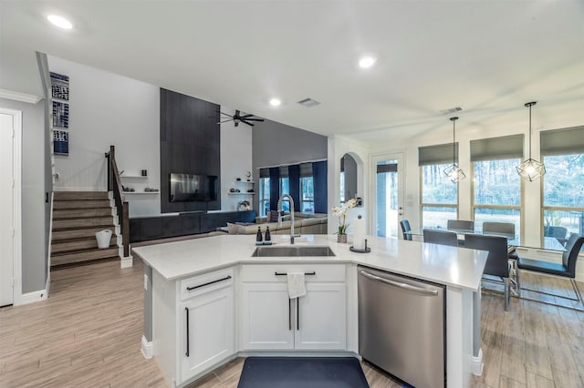 kitchen featuring white cabinetry, sink, an island with sink, and dishwasher