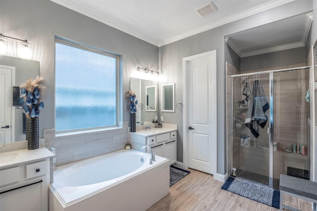 bathroom featuring ornamental molding, vanity, independent shower and bath, and wood-type flooring