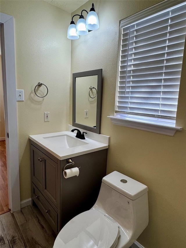 bathroom featuring vanity, toilet, and hardwood / wood-style floors