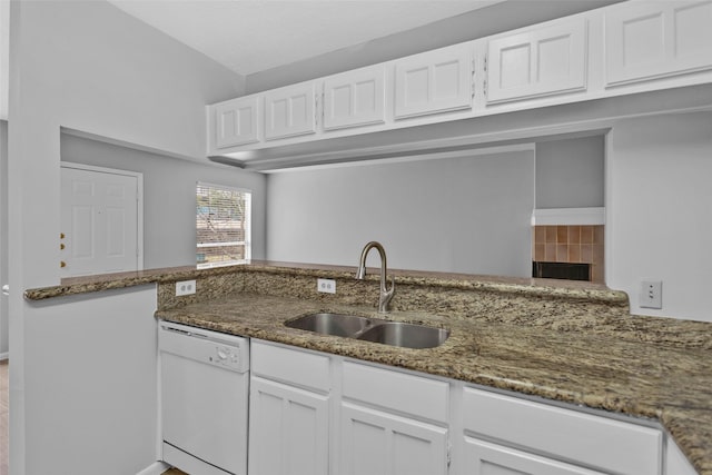 kitchen with white dishwasher, sink, dark stone countertops, and white cabinets