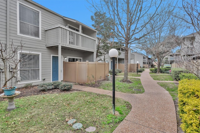 view of property exterior featuring a balcony and a yard