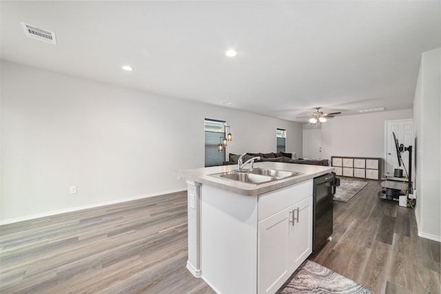 kitchen with sink, light hardwood / wood-style flooring, dishwasher, white cabinetry, and a kitchen island with sink