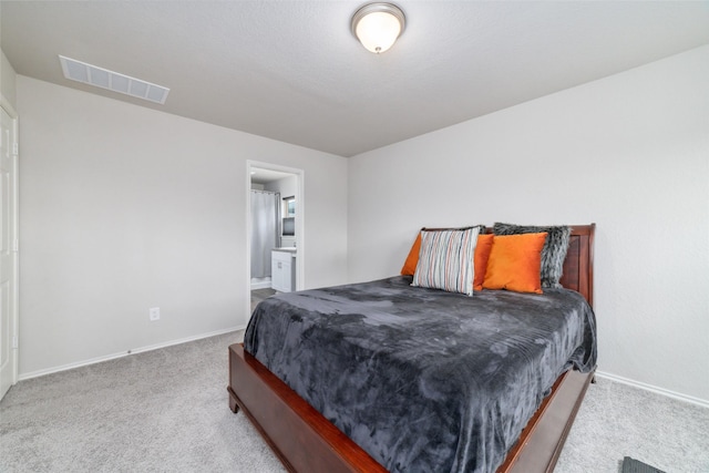 carpeted bedroom featuring ensuite bath