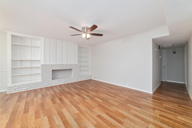 unfurnished living room featuring a brick fireplace, built in features, light hardwood / wood-style floors, and ceiling fan