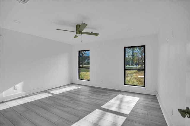 unfurnished room featuring light hardwood / wood-style flooring, plenty of natural light, and ceiling fan