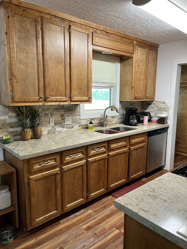 kitchen with sink, a textured ceiling, dark hardwood / wood-style flooring, dishwasher, and decorative backsplash