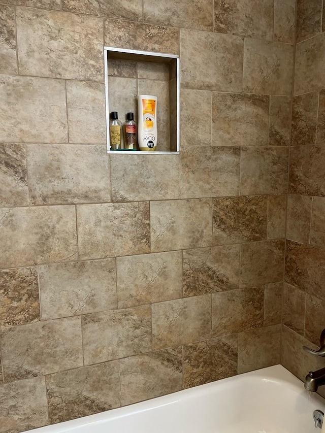 details featuring tiled shower / bath combo