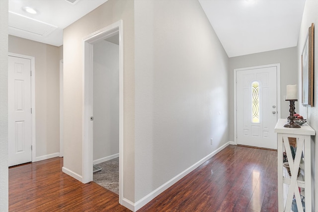 foyer featuring dark wood-type flooring and vaulted ceiling