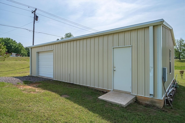 view of outbuilding featuring a garage and a yard